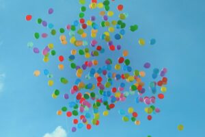 multi colored balloons released into sky